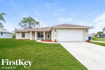 Lehigh Acres house for rent - a white house with a lawn and a driveway