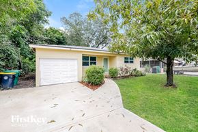 Dania Beach house for rent - a yellow house with a driveway and a white garage door