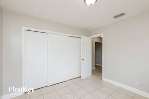 Dania Beach house for rent - a bedroom with two closets and a door to a hallway