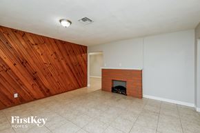 Dania Beach house for rent - the living room has a brick fireplace and a wood accent wall