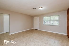 Dania Beach house for rent - the living room of an empty house with a tile floor and a window