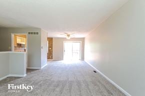 Indianapolis house for rent - A carpeted room with a white wall and a doorway leading to another room.