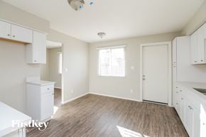 Glendale house for rent - a kitchen and dining room with white cabinets and wood flooring