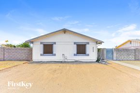 Phoenix house for rent - A small white house with a brown roof and a brown fence.