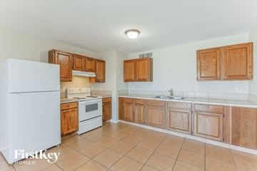 Phoenix house for rent - A kitchen with wooden cabinets and a white refrigerator.