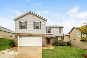 Pinson house for rent - a house with a white garage door in front of a yard
