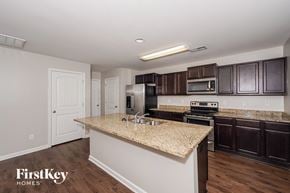 Pinson house for rent - a kitchen with granite countertops and dark wood cabinets