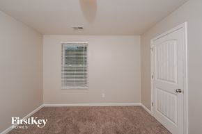 Pinson house for rent - a bedroom with a carpeted floor and a white door