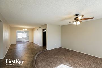 Glendale house for rent - a spacious living room with a large rug and a ceiling fan