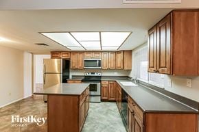 Glendale house for rent - a kitchen with wooden cabinets and stainless steel appliances