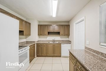 Plantation house for rent - a kitchen with granite counter tops and wooden cabinets