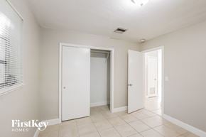 Plantation house for rent - a bedroom with two closets and a tiled floor and white walls and doors