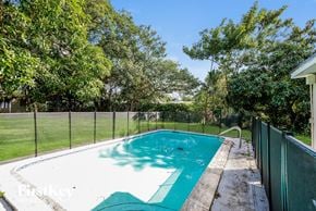 Plantation house for rent - a swimming pool in a backyard next to a fence