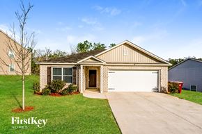 Pinson house for rent - a house with a white garage door in front of a yard