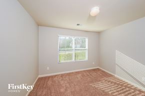 Pinson house for rent - a spacious room with carpet and a large window