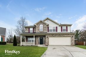 Greenwood house for rent - a home with a white garage door and a brick house with pink shutters
