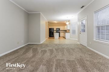 Greenwood house for rent - a spacious living room with carpet and a kitchen