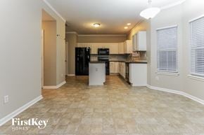 Greenwood house for rent - the kitchen and living room of an open floor plan with a kitchen island and refrigerator