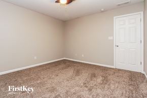Greenwood house for rent - a bedroom with a carpeted floor and a white door