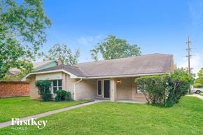 Houston house for rent - A house with a green lawn and a tree in front of it.