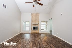 Houston house for rent - A room with a fireplace and a ceiling fan.
