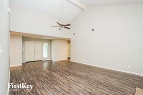 Houston house for rent - A spacious room with a ceiling fan and wooden flooring.