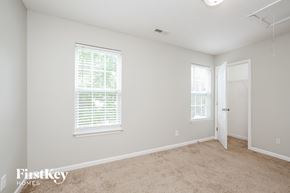 Greensboro house for rent - a bedroom with a carpeted floor and two windows
