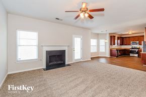 Cumming house for rent - A spacious living room with a fireplace and a ceiling fan.