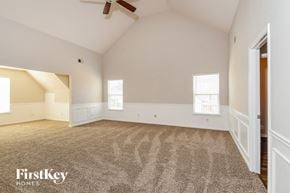 Cumming house for rent - A spacious room with a carpeted floor and a ceiling fan.