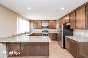 Tempe house for rent - a kitchen with wooden cabinets and granite counter tops and a stainless steel refrigerator