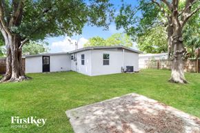 Tampa house for rent - a white house with a yard and some trees