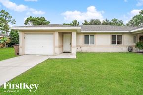 Lehigh Acres house for rent - A house with a garage and a driveway in front of it.