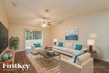 Lehigh Acres house for rent - A living room with a white couch and a ceiling fan.