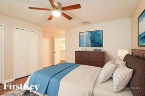 Lehigh Acres house for rent - A bedroom with a bed, dresser, and painting.