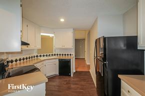 Sugar Hill house for rent - a renovated kitchen with white cabinets and black appliances