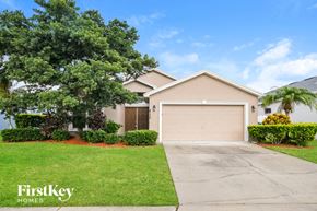 Winter Haven house for rent - a beige house with a driveway and a garage door