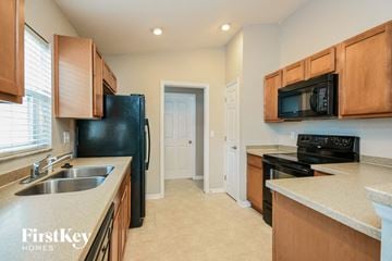 Winter Haven house for rent - a kitchen with a sink and a black refrigerator