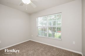 Winter Haven house for rent - a bedroom with a large window and a carpeted floor