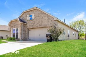 Mccalla house for rent - a brick house with a white garage door and a green lawn