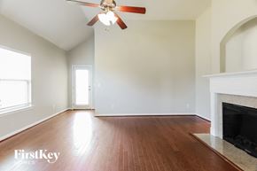 Mccalla house for rent - a empty living room with a ceiling fan and a fireplace