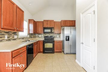 Mccalla house for rent - a large kitchen with wooden cabinets and stainless steel appliances
