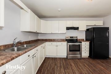 Phoenix house for rent - A kitchen with white cabinets and a black refrigerator.