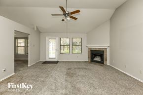 Arlington house for rent - an empty living room with a fireplace and a ceiling fan