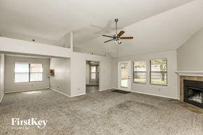 Arlington house for rent - an empty living room with a ceiling fan and a fireplace