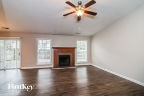 Alpharetta house for rent - a living room with a fireplace and a ceiling fan