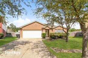 Kingwood house for rent - a brick house with a white garage door and a driveway