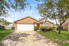 Kingwood house for rent - a home with a white garage door and a driveway