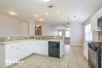 Kingwood house for rent - a kitchen with white cabinets and a black dishwasher