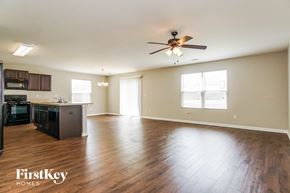 Bessemer house for rent - an empty living room and kitchen with wood floors and a ceiling fan