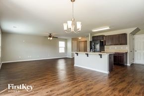 Bessemer house for rent - an open kitchen and living room with a white island and wood floors
